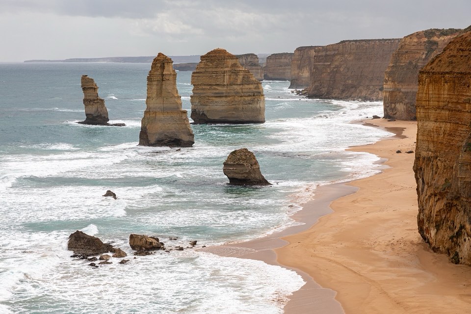 The Twelve Apostles limestone stacks rising from the sea beside a curved beach